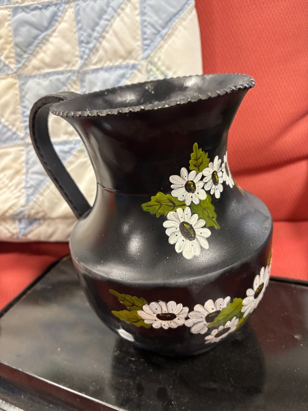 Vintage black metal pitcher with a hand-painted floral design